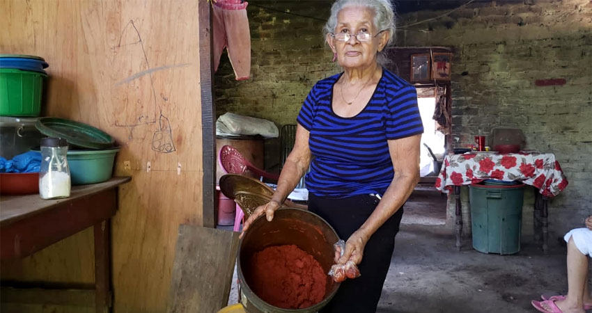 Doña Bernarda Rocha prepara achiote y un nieto le ayuda a vender. Foto: José Enrique Ortega/Radio ABC Stereo