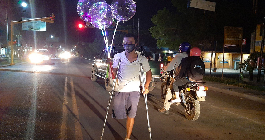 Pese a su discapacidad, Sergio David Moncada se arriesga en la carretera a vender globos. Foto: Famnuel Úbeda/Radio ABC Stereo